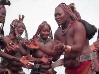 Afrikietiškas himba moterys šokis ir sūpynės jų saggy papai aplink